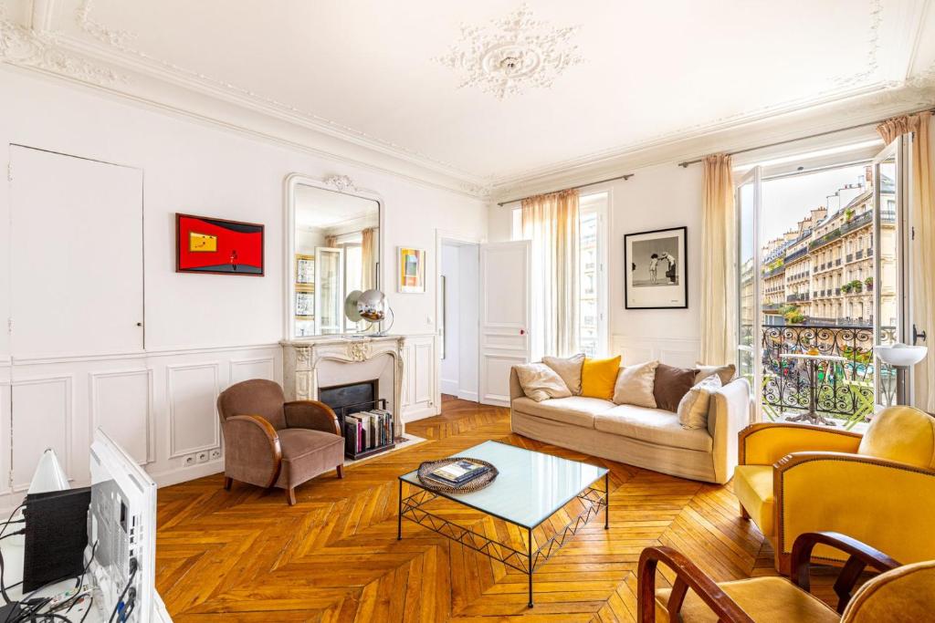 un salon avec un canapé et une cheminée dans l'établissement GuestReady - Appartement Parisien dans le 10ème, à Paris