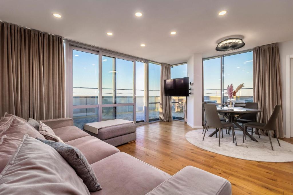 a living room with a couch and a table at Elija Penthouse in Palanga