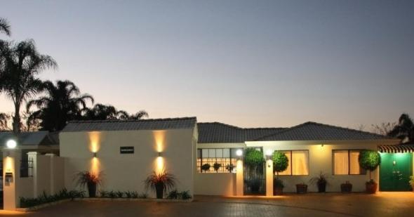 una gran casa blanca con palmeras y luces en Astoria Retreat Bed & Breakfast, en Perth