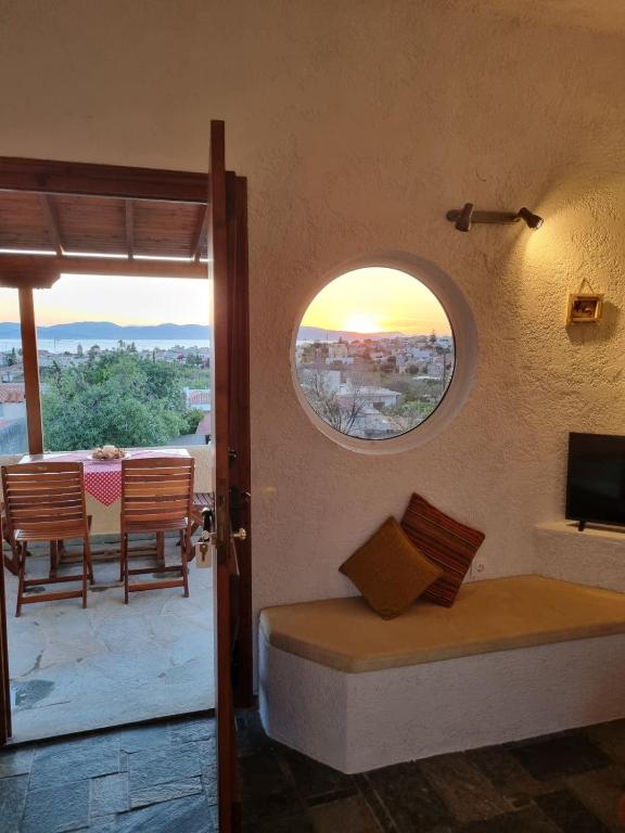 a room with a bed and a table and a window at Fay's View Aegina in Egina