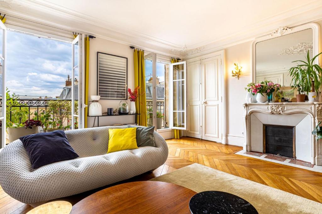 un salon avec un canapé et une cheminée dans l'établissement GuestReady - Stately Haven near Pantheon, à Paris
