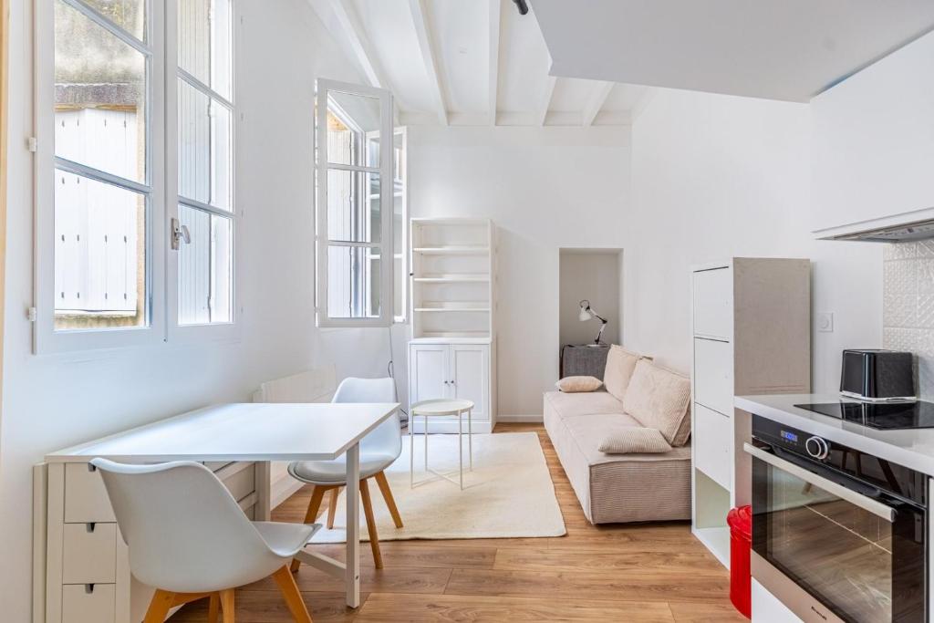 une cuisine et un salon avec une table et des chaises dans l'établissement GuestReady - A Downtown stay in Bordeaux, à Bordeaux