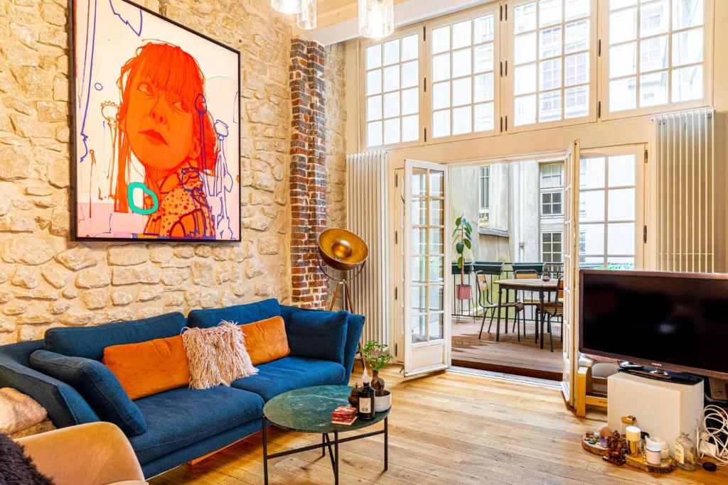 - un salon avec un canapé bleu et un mur en briques dans l'établissement GuestReady - One glorious stay in Le Marais, à Paris