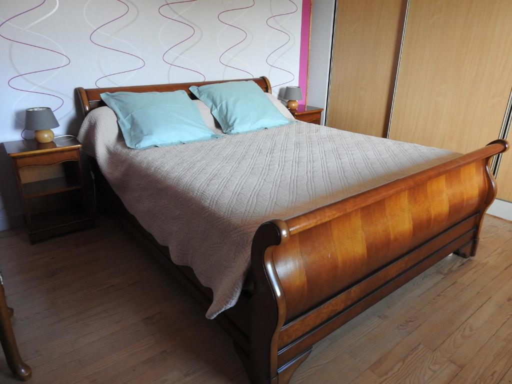 a bed with two blue pillows on it in a bedroom at Domaine des Gardette in Vaux-en-Beaujolais