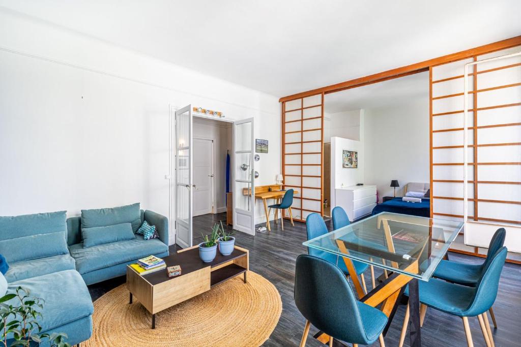 un salon avec un canapé bleu et une table en verre dans l'établissement GuestReady - Bel Appartement au 16ème arr., à Paris