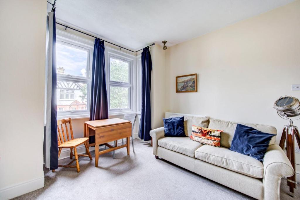 een woonkamer met een bank en een tafel bij GuestReady - Harrow Delight near Recreation Ground in Londen
