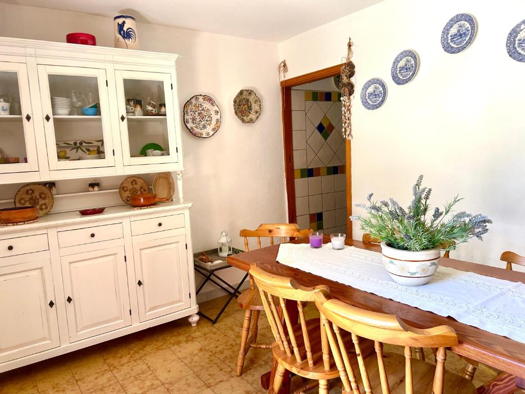 een keuken met een tafel en stoelen en borden aan de muur bij Nura's - Casa Gea in Stintino