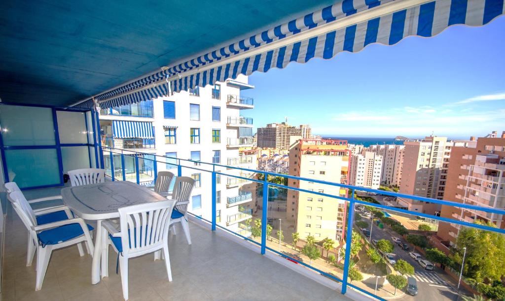 einen Balkon mit einem Tisch und Stühlen sowie Stadtblick in der Unterkunft CALA VENT MAR Y SOL Poniente Beach in Benidorm