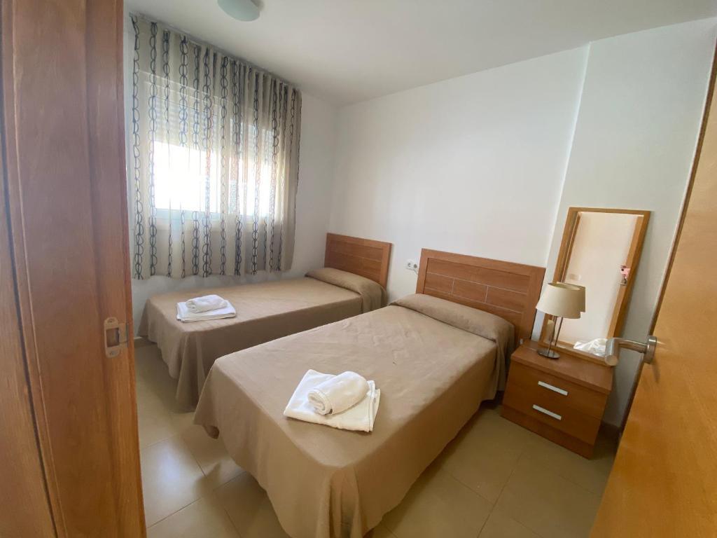 a hotel room with two beds and a mirror at Condado de Alhama, Jardín 5, 497 in El Romero