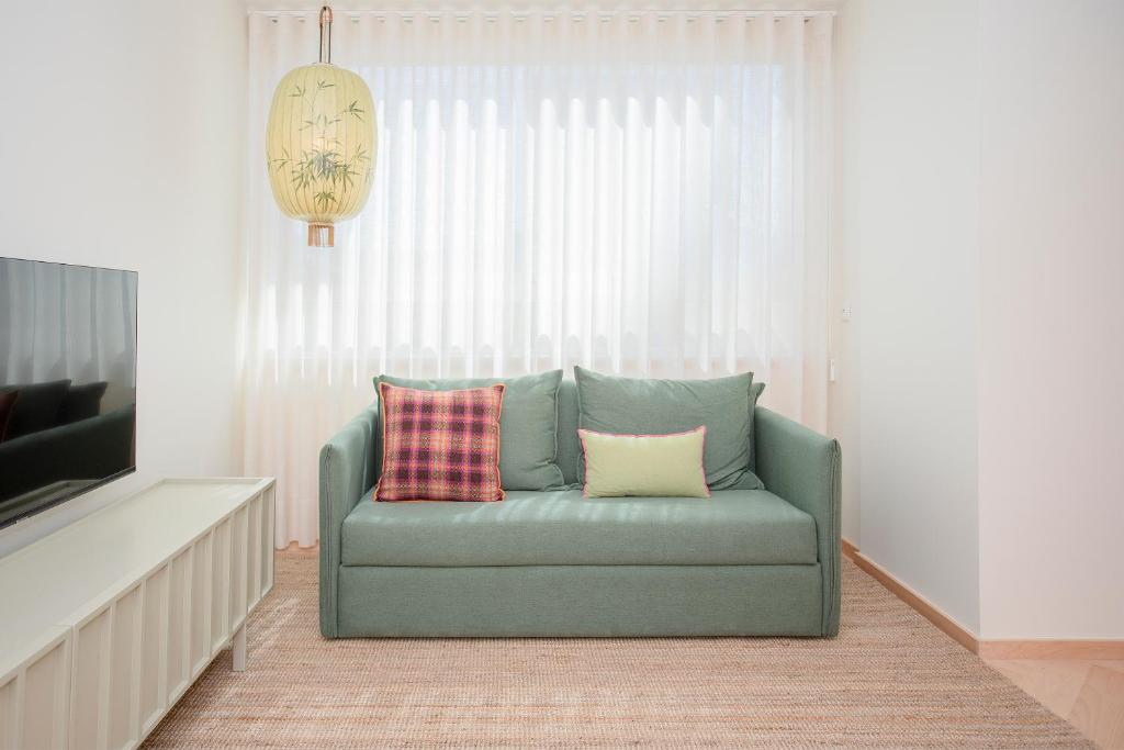 kanapę z dwoma poduszkami w salonie w obiekcie Allegro Boutique Apartments by Liiiving w Porto