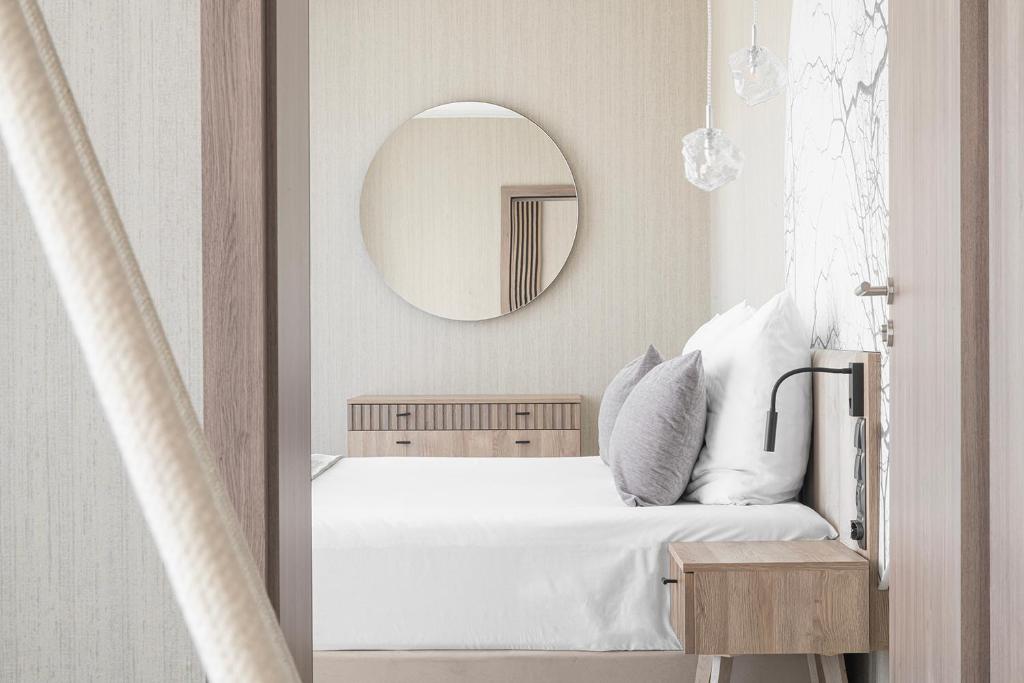 Schlafzimmer mit einem weißen Bett und einem Spiegel in der Unterkunft Hotel Astor in Jastrzębia Góra