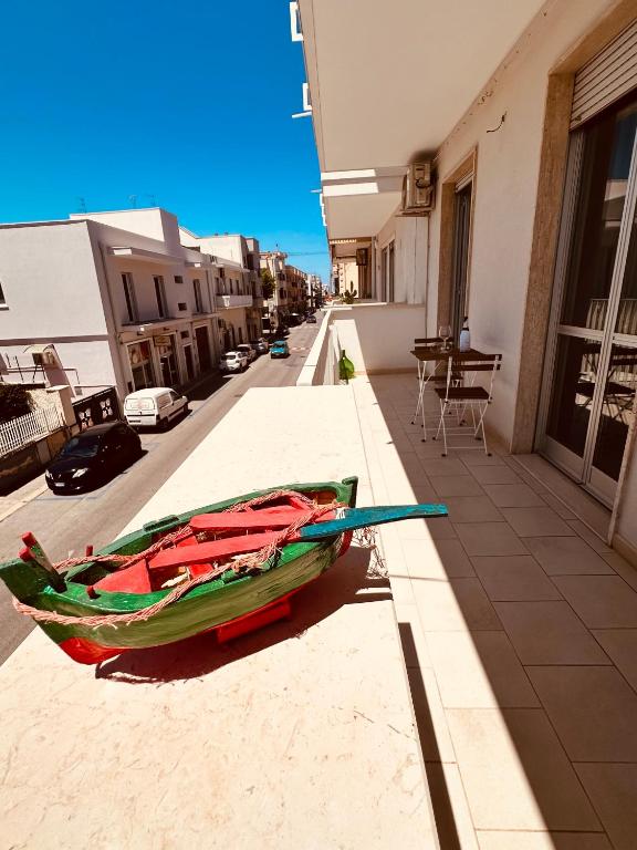 a green boat sitting on the side of a building at Domus Angela in Polignano a Mare