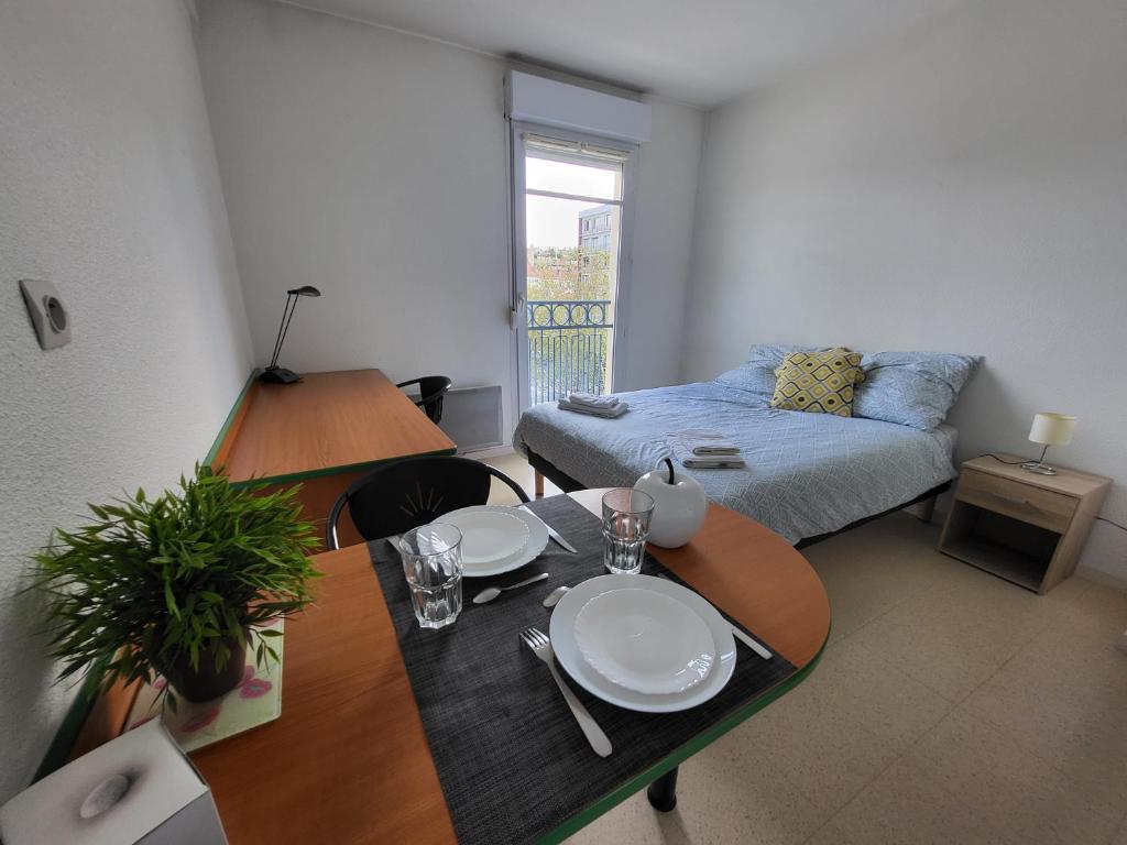 聖艾蒂安的住宿－NEORESID RESIDENCE TREFILERIE，客厅配有桌子和床。