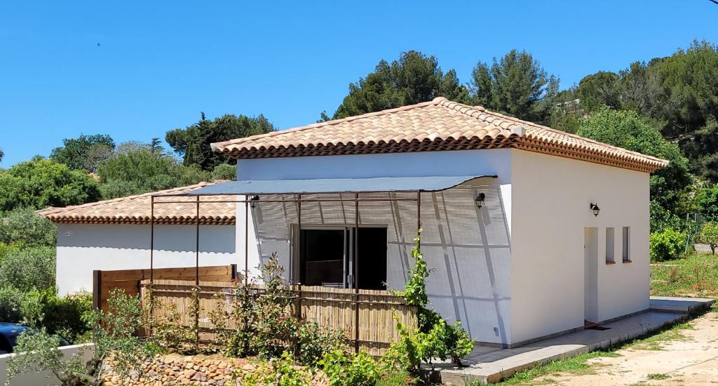 een klein wit huis met een hek bij Jolie maison neuve entre mer et colline en Provence in Ollioules