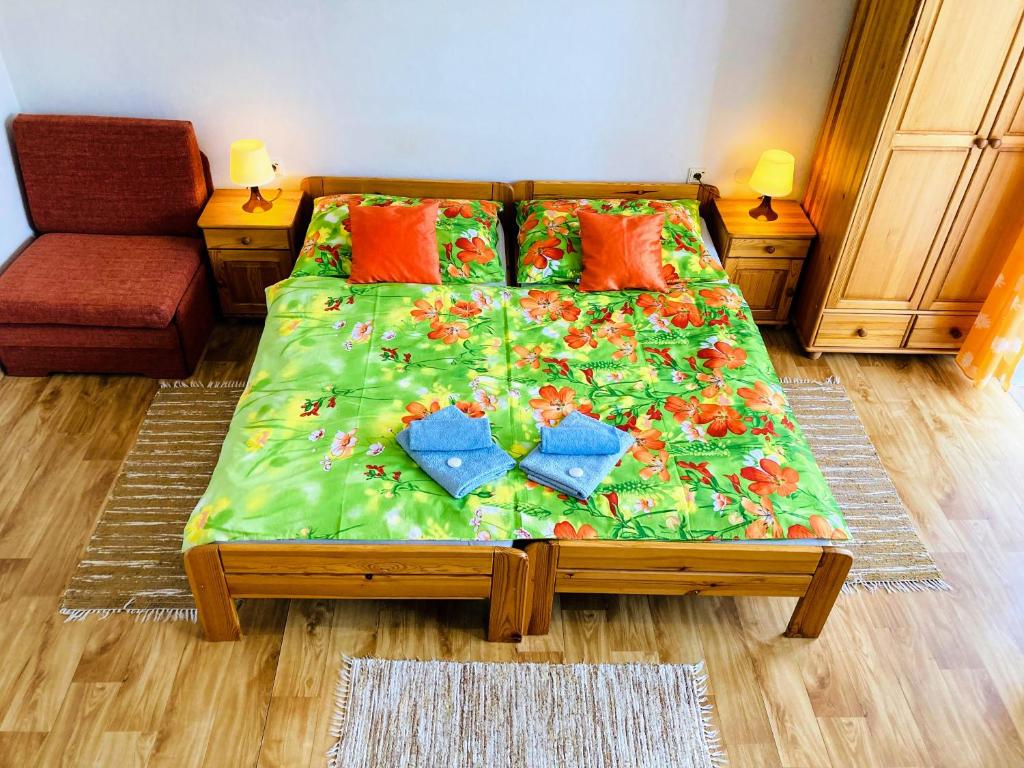 1 dormitorio con 1 cama con edredón verde en Apartmány Horalka, en Liptovský Mikuláš
