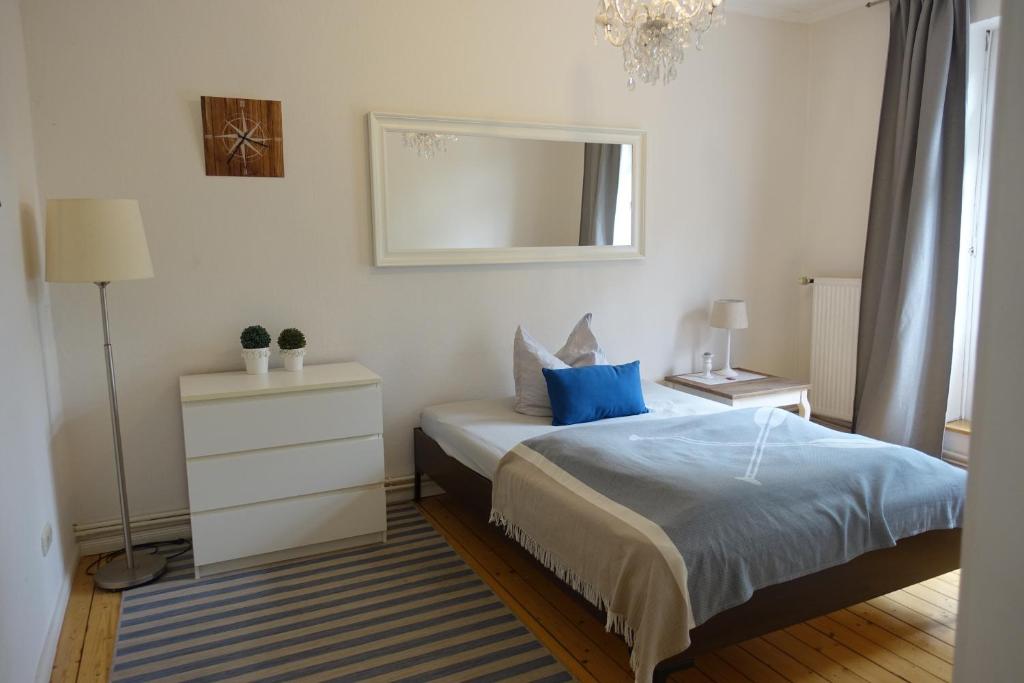 sypialnia z łóżkiem z niebieską pościelą i lustrem w obiekcie Gr Wohnung mit 3 sep Schlafzimmern w Bremie