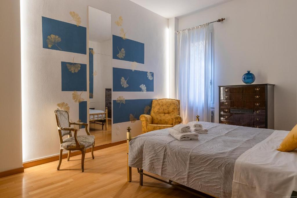 a bedroom with blue and white walls and a bed and chairs at HouSmart Cartoleria 8 in Bologna