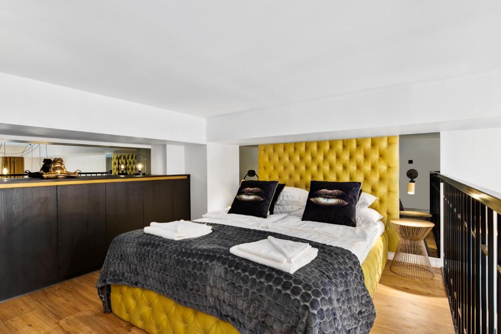 a bedroom with a large bed with a yellow headboard at Golden Residence in Tartu Center by EasyRentals in Tartu