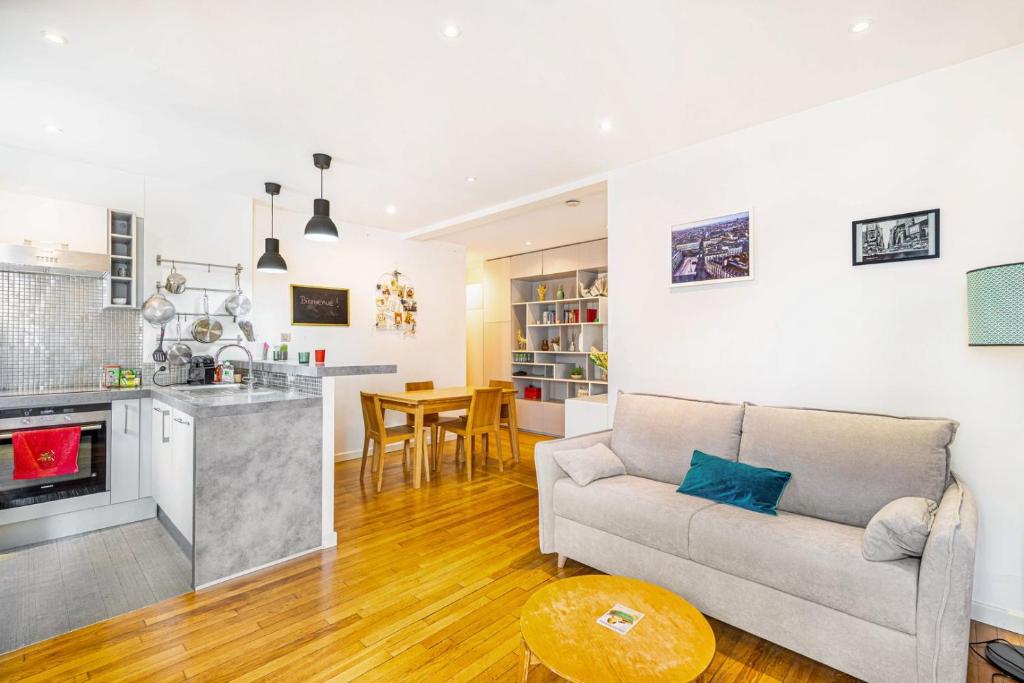 un salon avec un canapé et une cuisine dans l'établissement GuestReady - Stay in the heart of Paris, à Paris