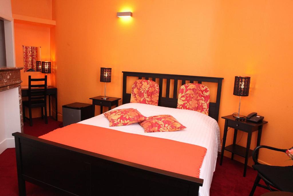 a bedroom with a bed with two pillows on it at Eurotel in Liège