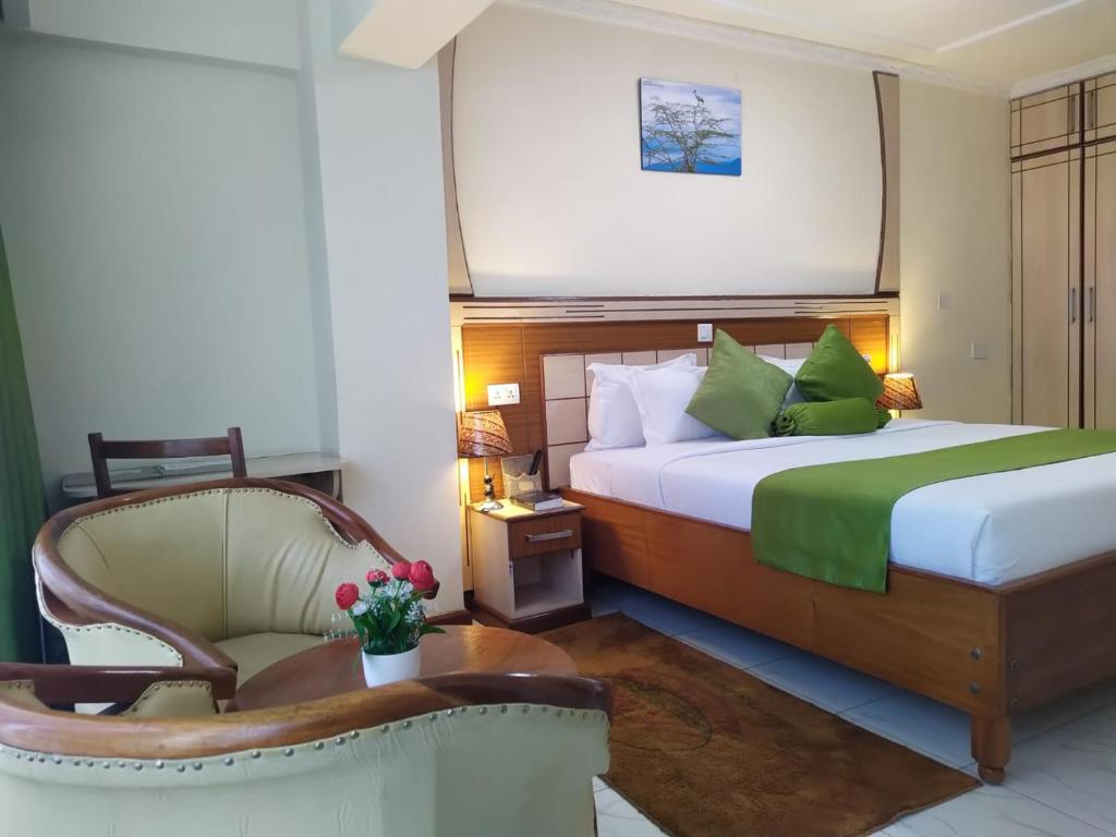 ein Hotelzimmer mit einem Bett und einem Stuhl in der Unterkunft Empolos Hotel Nakuru in Nakuru