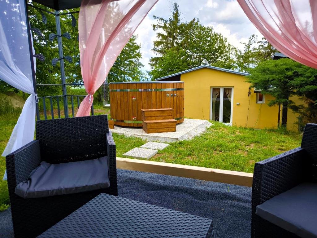 patio z 2 krzesłami i żółtym domem w obiekcie Ranch 66 - Zlatokopecká chata Arizona w mieście Tršice