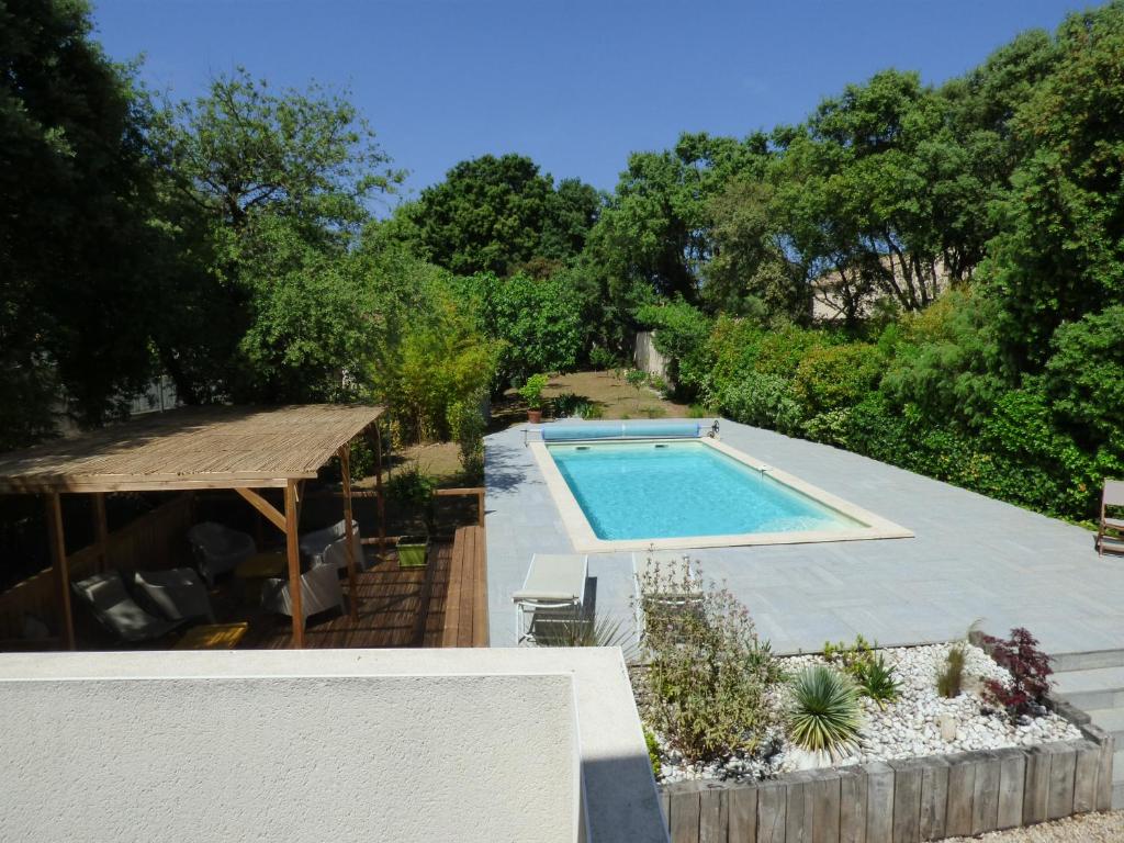 une piscine au milieu d'un jardin dans l'établissement chambre d'hôte chez Suzel, à Sussargues