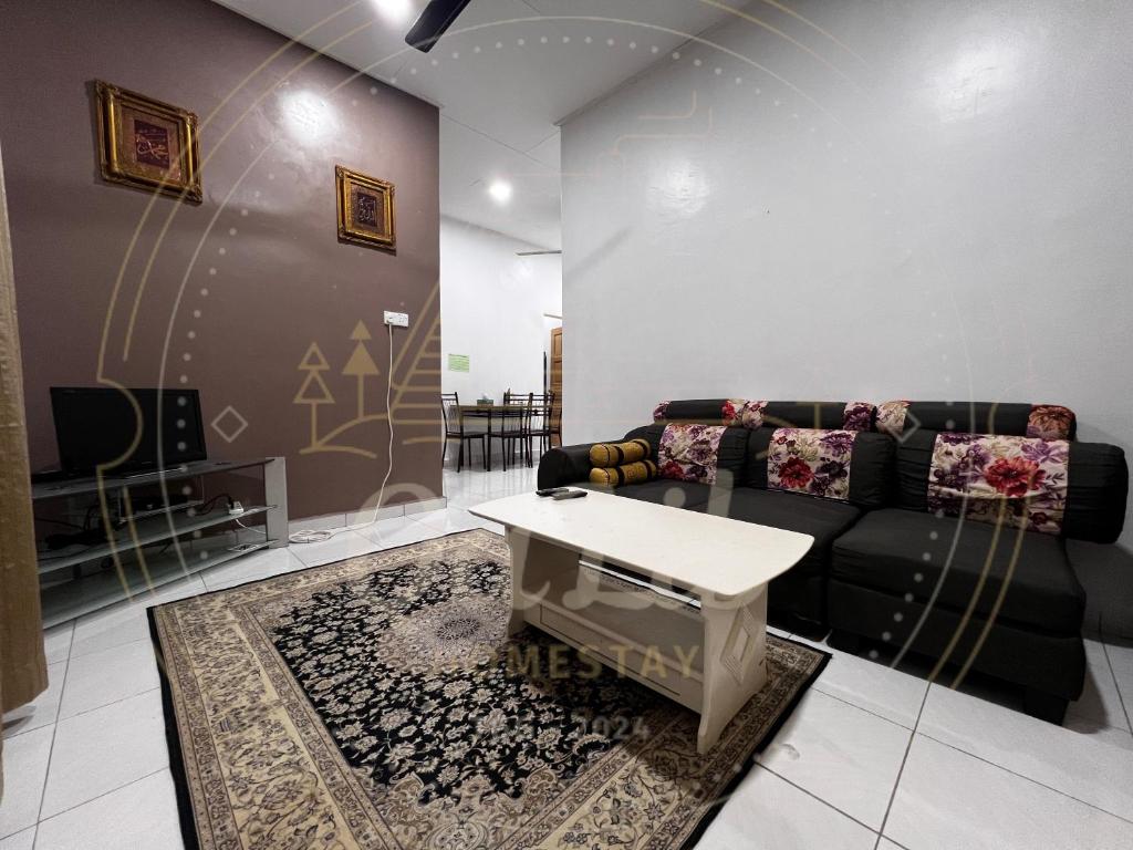 een woonkamer met een bank en een tafel bij QALIB HOMESTAY in Kuala Terengganu