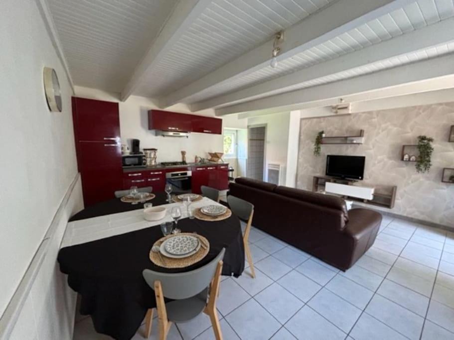 un salon avec une table et un canapé dans l'établissement Petite maison à la campagne, à Mespaul