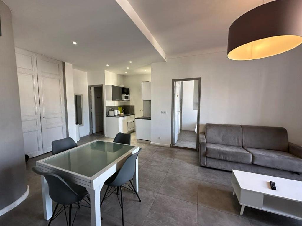 un salon avec un canapé, une table et des chaises dans l'établissement B081 - Bel appartement Cannes - Tassigny, à Cannes