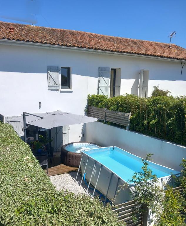 une maison avec une piscine et un parasol dans l'établissement Maison de ville, Piscine, terrasse et jardin privé, à Bayonne
