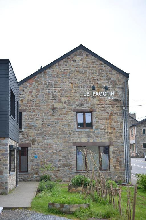 un edificio di mattoni con una misericordia sopra di Le Fagotin - Youth hostel a Stoumont