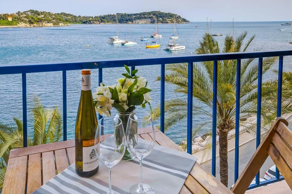 une bouteille de vin posée sur une table avec des verres dans l'établissement Stunning Waterfront Apartment, à Villefranche-sur-Mer