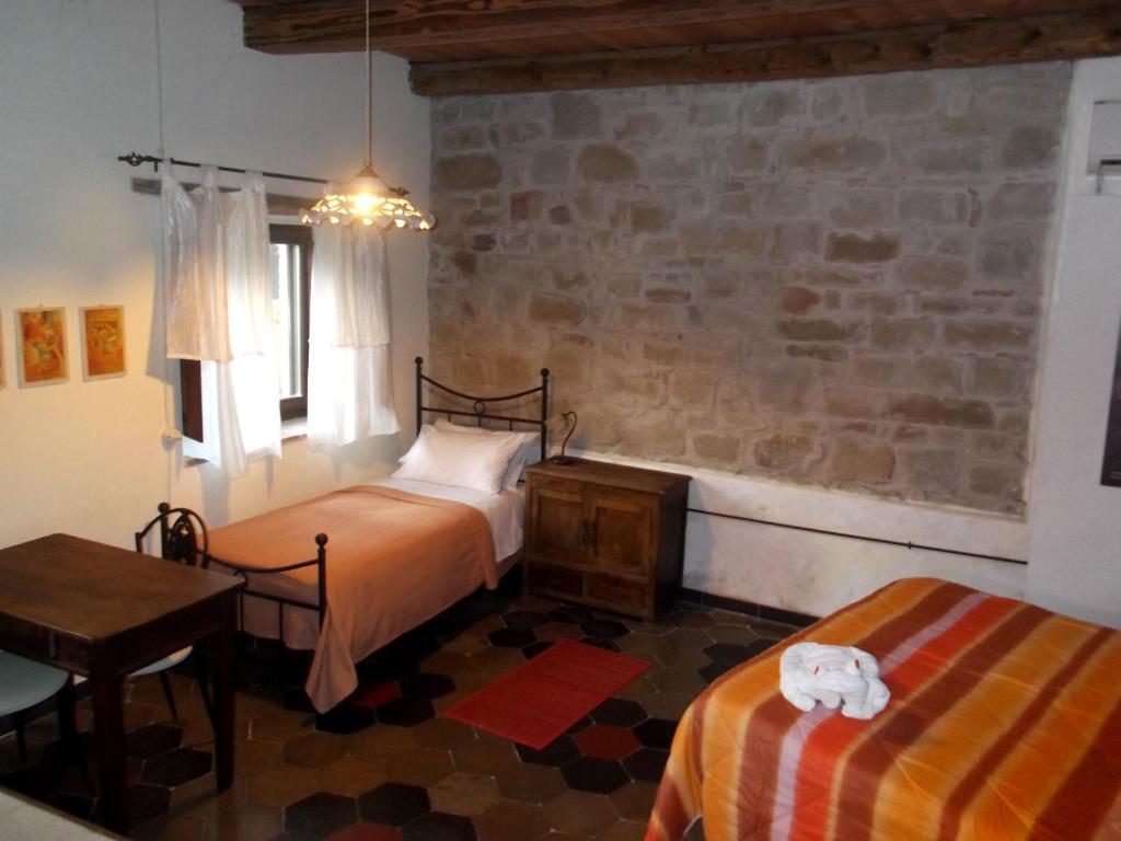 1 dormitorio con 2 camas, mesa y silla en Locanda dell'Istrice en Camerino