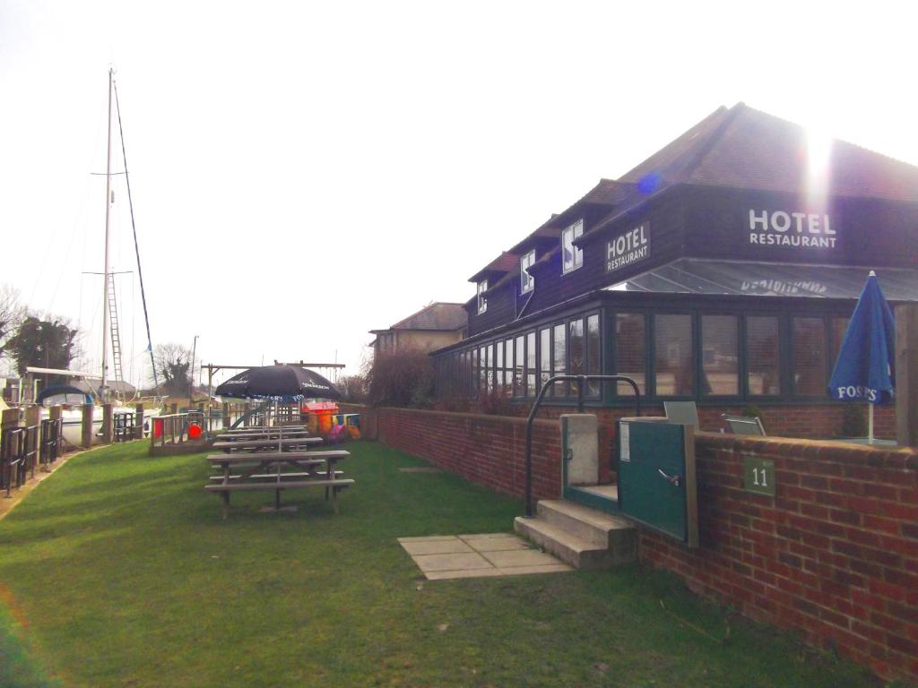 un grupo de mesas de picnic frente a un edificio en The River Haven Hotel, en Rye