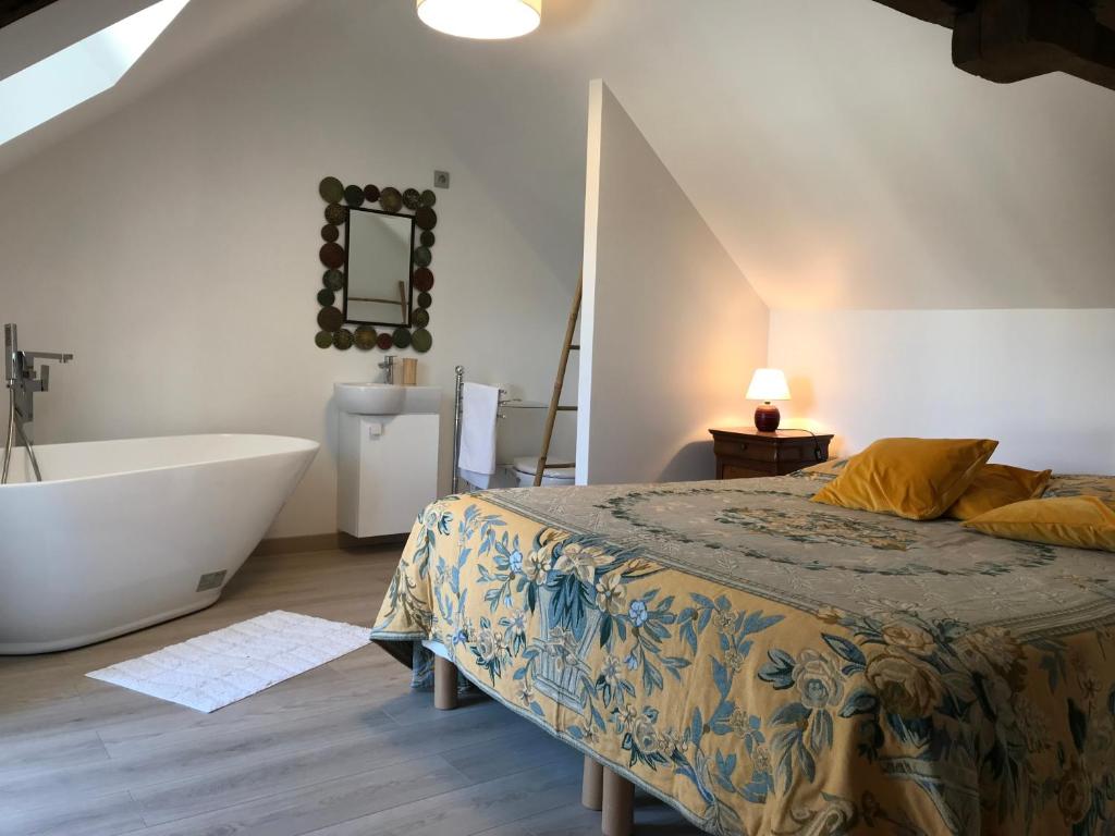 um quarto com uma cama, uma banheira e um lavatório em Relais du Chat Prosper em Lescherolles