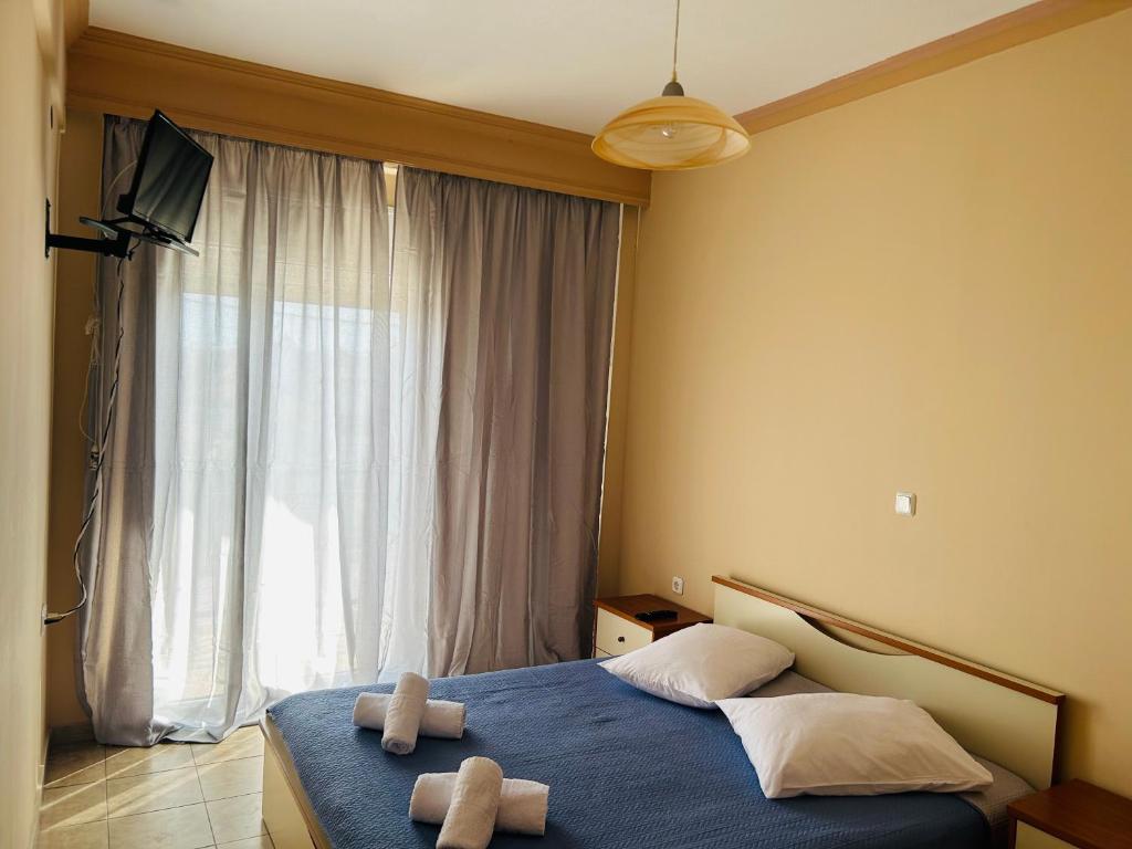 1 dormitorio con 2 toallas en una cama con ventana en Apartments Spartacus en Polykhrono