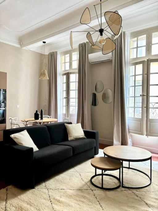 un salon avec un canapé noir et une table dans l'établissement Splendide T2 au coeur d'Aix et du Cours Mirabeau, à Aix-en-Provence