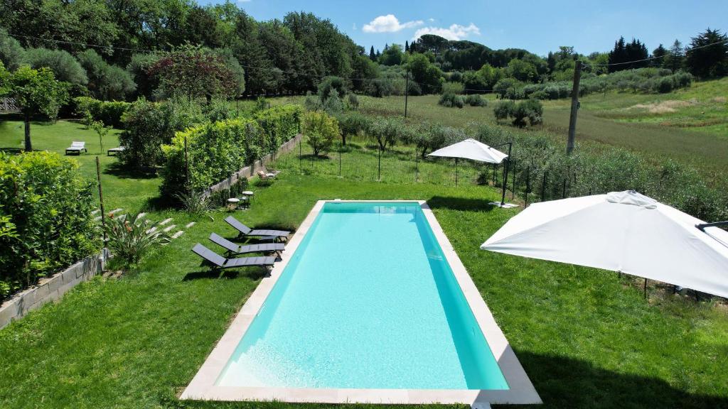 een zwembad in een veld met een parasol bij Dimora Rosa Bianca in Macerata