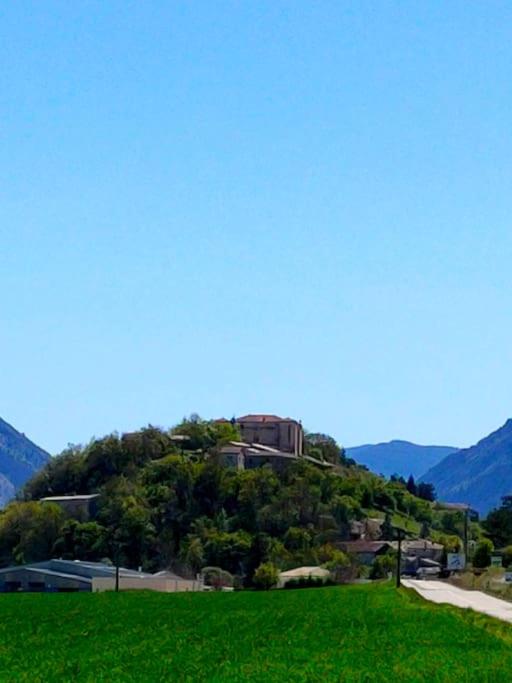 une maison au sommet d'une colline avec de l'herbe verte dans l'établissement Appartement dans maison individuelle, à Recoubeau-Jansac