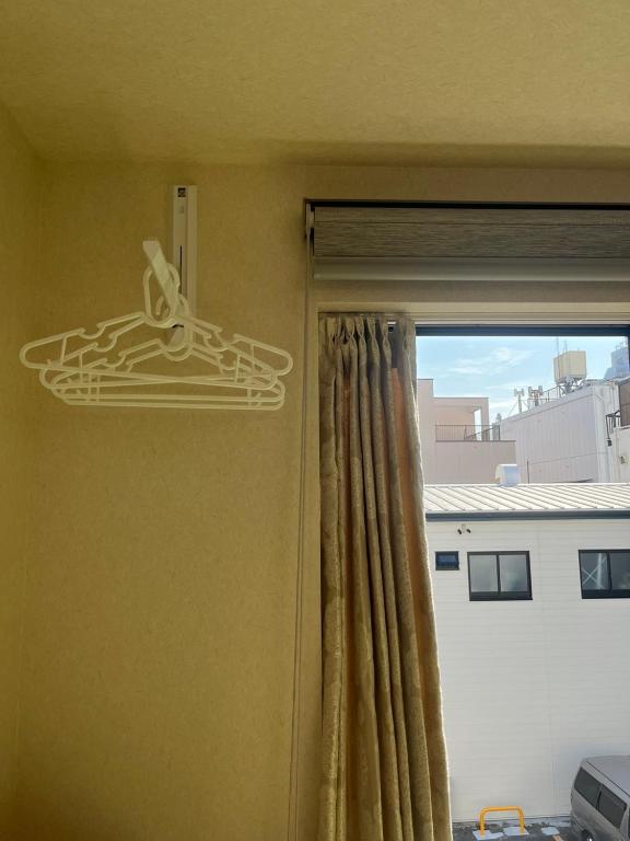 a room with a window with a curtain and a window at DainHostel2 in Tokyo