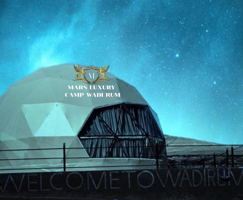 瓦迪拉姆的住宿－MARS LUXURY CAMP WADi RUM，一座带夜间标志的圆顶建筑