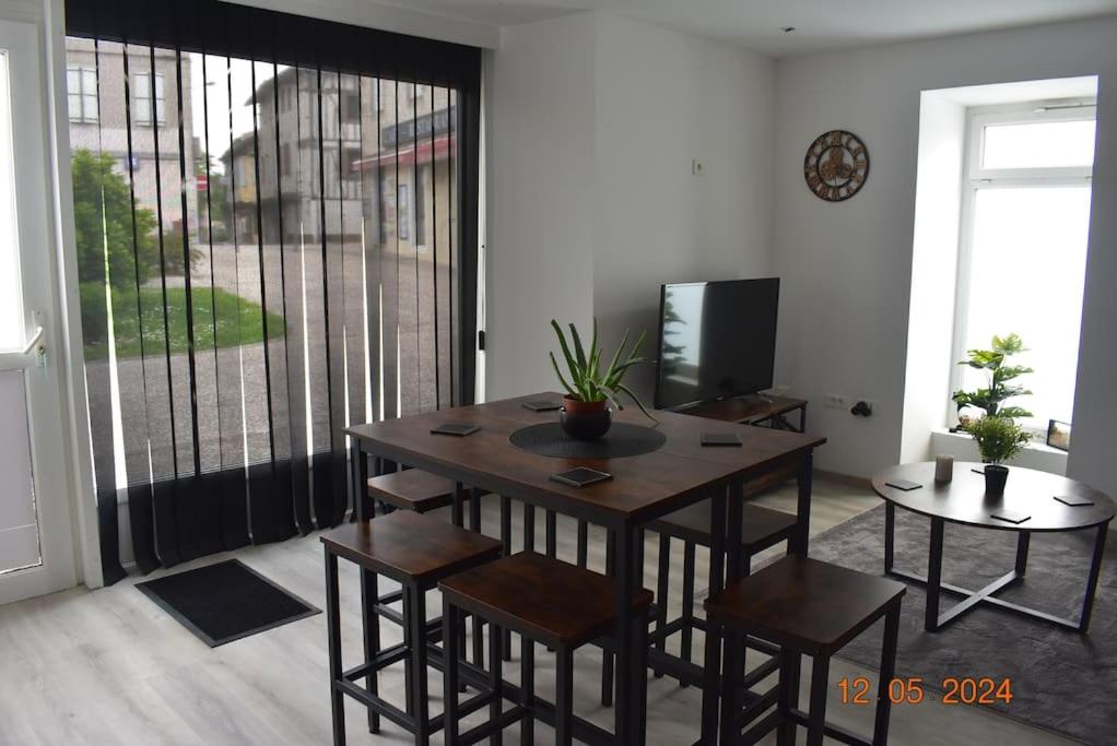 un salon avec une table, des chaises et une télévision dans l'établissement Charmant RDC au Cœur du village, à Soual