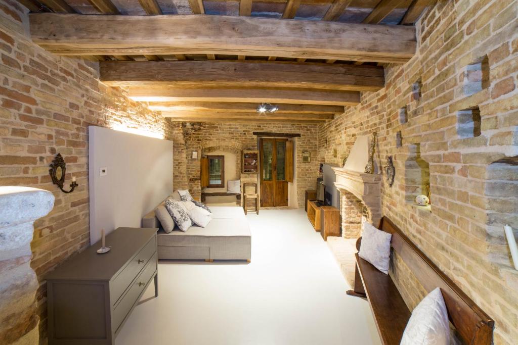 ein Wohnzimmer mit Ziegelwand in der Unterkunft The Monastery - Unique Vacation Home in Monteprandone