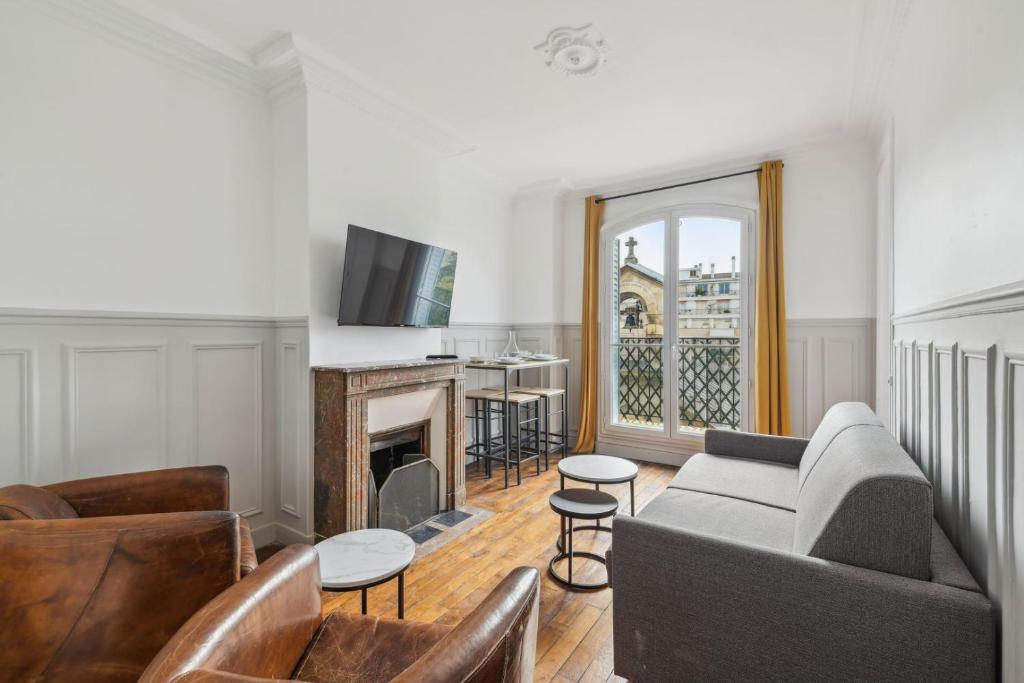un salon avec un canapé et une cheminée dans l'établissement 550 Suite Quinault - Superbe Appartement à Paris, à Paris