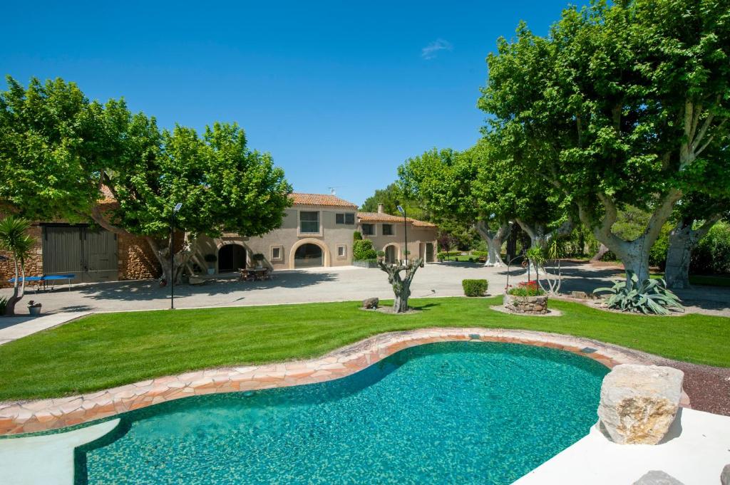 - une piscine dans une cour avec des arbres et une maison dans l'établissement Mas Amande - Maisons mitoyennes avec piscine, à Istres