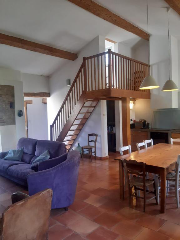 - un salon avec un canapé bleu et une table en bois dans l'établissement Le Pigeonnier au dessus du lac, à Caraman