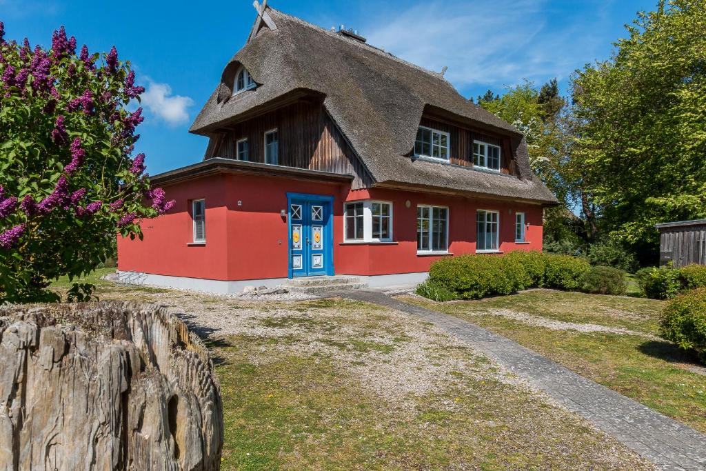 a red house with a thatched roof at An den Boddenwiesen 01 in Wieck