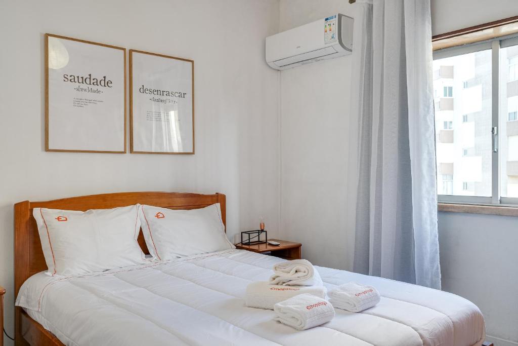 una camera da letto con un letto con due asciugamani sopra di Hopstays - Almada Saudade ad Almada