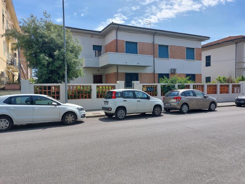 un groupe de voitures garées devant un bâtiment dans l'établissement Villa Mehari, à Pise